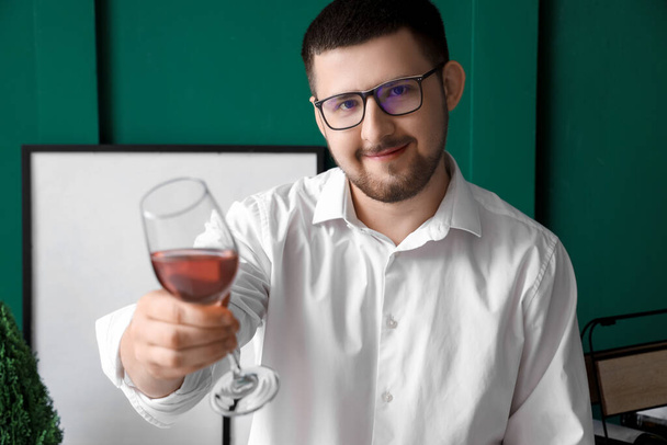Νεαρός σομελιέ με ποτήρι κρασί στο σαλόνι - Φωτογραφία, εικόνα