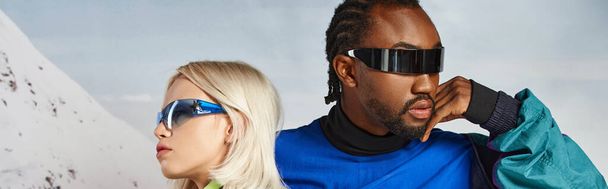 voguish νεαρό πολυπολιτισμικό ζευγάρι με κομψά γυαλιά ηλίου ποζάρουν μαζί, χειμωνιάτικο concept, banner - Φωτογραφία, εικόνα