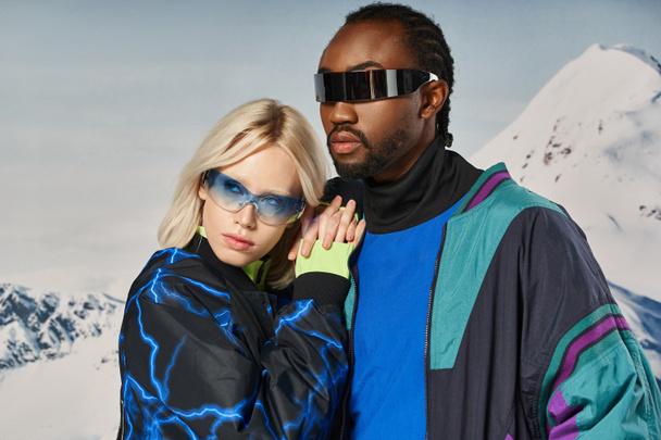 loving stylish interracial couple in warm vibrant attire hugging and looking away, winter concept - Photo, Image