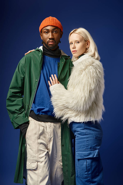 multiethnic couple posing in winter attire with mountain on backdrop, african american man and woman - Photo, Image