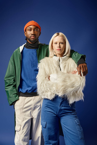 multiethnic couple posing in winter attire with mountain on backdrop, african american man and woman - Fotografie, Obrázek