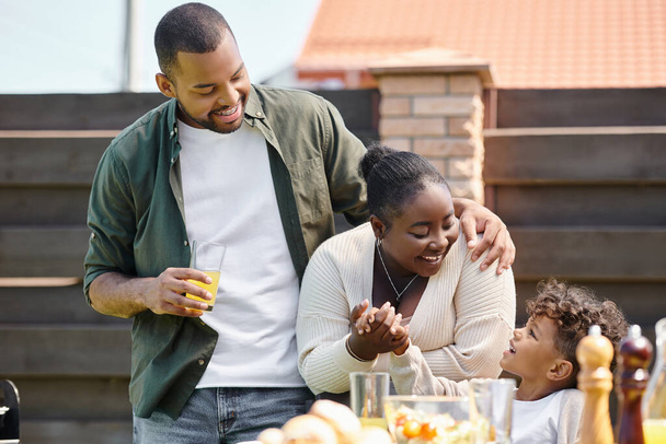 ritratto di felice afro-americano genitori e figlio avendo famiglia bbq partito sul cortile di casa - Foto, immagini