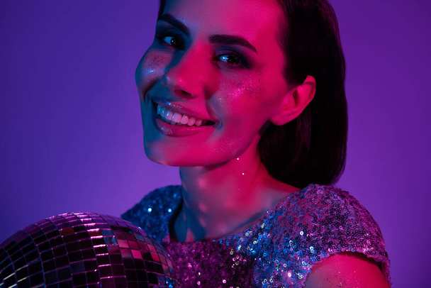 Portrait de dame fantaisie bachelorette sourire avec boule disco profiter de la célébration du bal isolé fond néon ultraviolet. - Photo, image
