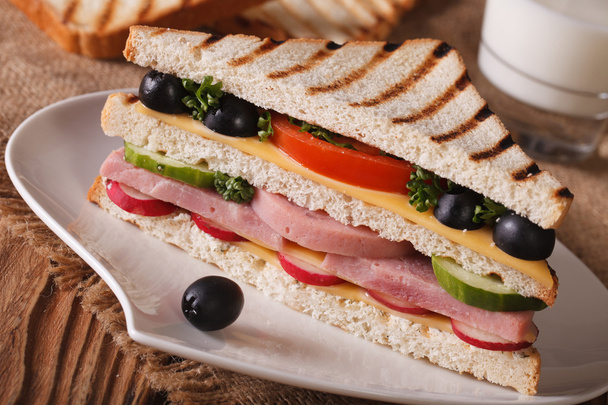 Sandwich with ham on a plate and milk. Horizontal closeup - Photo, Image