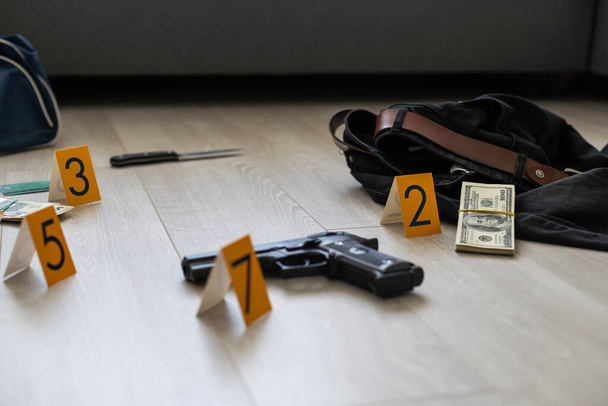 Image à contraste élevé d'une scène de crime avec arme à feu et marqueurs sur le sol. Photo de haute qualité - Photo, image