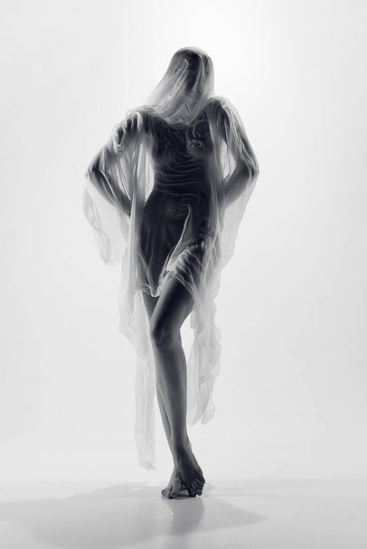 Full length portrait of naked tender young ballerina posing covered transparent fabric in monochrome retro photo effect. Charming beautiful model. Natural beauty of female body, femininity concept. - Photo, Image