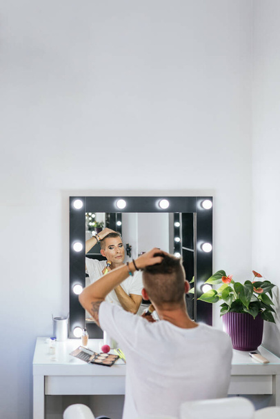 Vertical photo of a gay man making up alone in backstage - Photo, Image