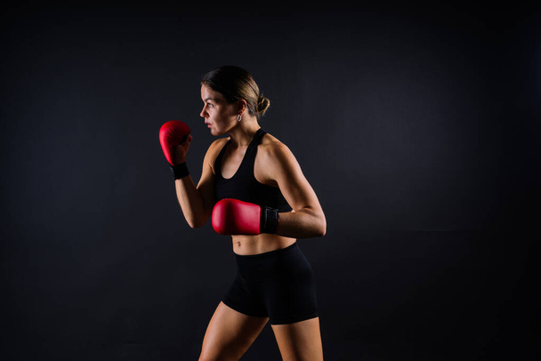 Young woman athletic female MMA fighter is training. Concept of sport, action, healthy lifestyle. - Foto, imagen