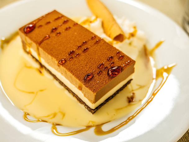 Una vista de arriba hacia abajo de un delicioso pastel de tiramisú de chocolate y crema blanca con azúcar caramelizada en la parte superior - Foto, Imagen