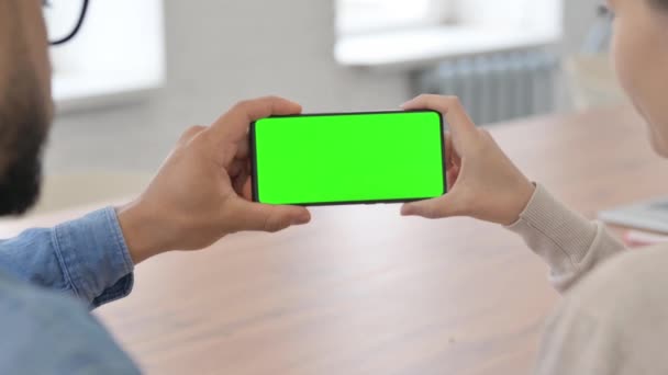 Вид сзади Молодые люди держат телефон горизонтальный с зеленым экраном - Кадры, видео