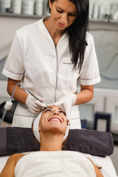 Знімок красивої молодої жінки на мікродермабразії лікування обличчя в салоні краси. - Фото, зображення