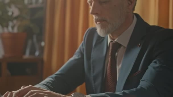 Наклон среднего возраста кавказский предприниматель в костюме работает на ноутбуке, сидя за столом в ресторане - Кадры, видео