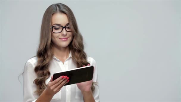 Retrato de una joven empresaria usando tableta aislada sobre fondo blanco
 - Metraje, vídeo