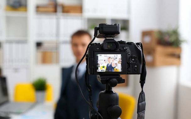 スーツとネクタイの男性を示す記号腕作るオフィス ビデオカメラ三脚クローズ アップするプロモーション videoblog またはフォト セッションを確認します。ビデオブロガー プロモーション selfie ソリューションまたは金融アドバイザーの管理情報 - 写真・画像