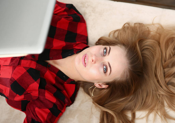Młoda ładna kobieta leżeć na kanapie pracy na laptopie wolna yime koncepcji - Zdjęcie, obraz
