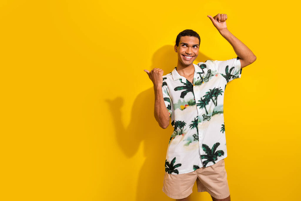 Photo of cheerful positive guy wear stylish clothes two thumbs direct empty space poster ad isolated on vivid yellow color background. - Φωτογραφία, εικόνα