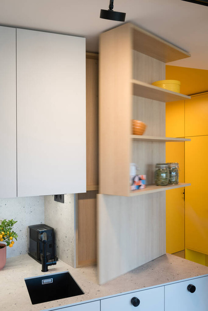 Meuble de cuisine personnalisé avec disjoncteur caché dans un petit appartement urbain - Photo, image