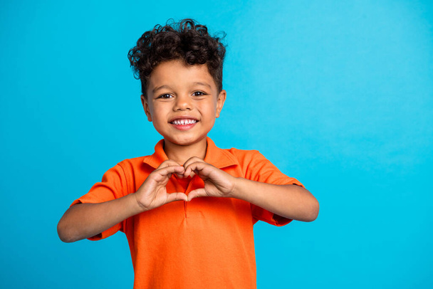 Photo of kid boy make hands love heart symbol isolated on blue color background. - Photo, image