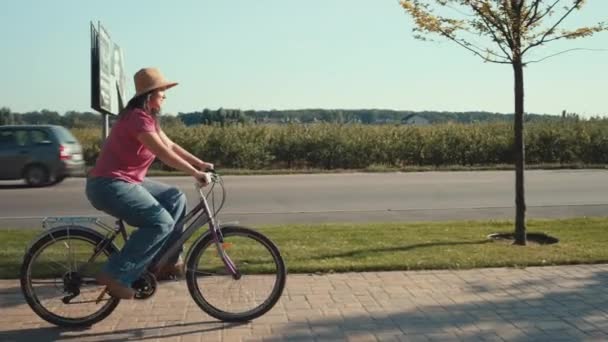 Kobieta jeździ rowerem poziomym po ulicach rowerowych w mieście. Aktywny wypoczynek i sport. Szczęśliwa i uśmiechnięta dziewczyna. Wysokiej jakości materiał 4k - Materiał filmowy, wideo