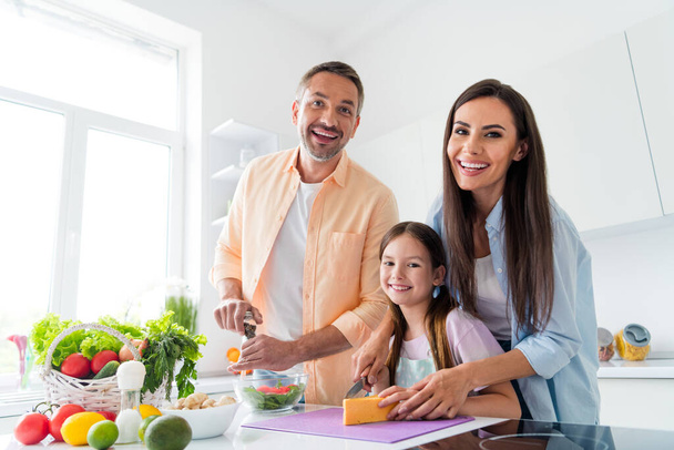 Photo of charming positive married couple small daughter enjoying cooking tasty breakfast together indoors home kitchen. - Valokuva, kuva