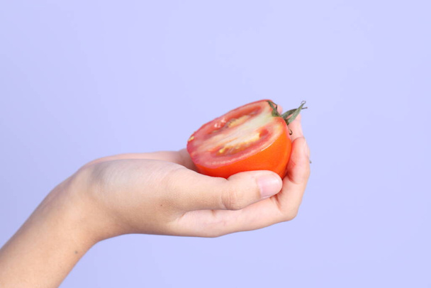 A mão mulher asiática segurando pomelo no fundo roxo. - Foto, Imagem