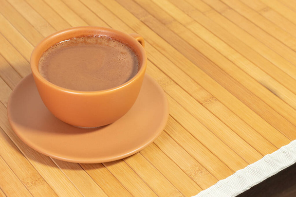 Mała filiżanka zimnej czekolady odizolowana na drewnianym stole. Obraz z przestrzenią do kopiowania. - Zdjęcie, obraz