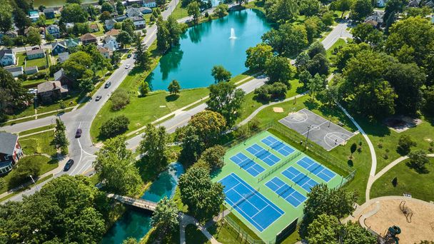 Imagem da ponte Lakeside Park perto de quadras de tênis e quadra de basquete com bairro e lagoa aérea - Foto, Imagem