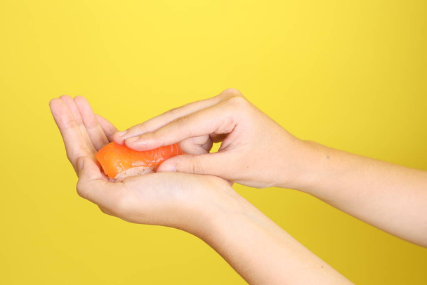 La mano asiática sosteniendo sushi en el fondo púrpura. - Foto, imagen