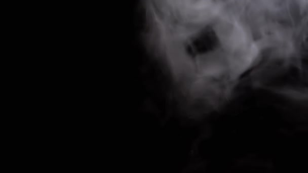 Nube helada de humo blanco grueso, niebla flotando sobre un fondo negro borroso. Resumen, aislado. Espacio vacío. Movimiento borroso. Bokeh, efecto. Humo suave o textura y estructura de vapor. Movimiento lento. - Metraje, vídeo