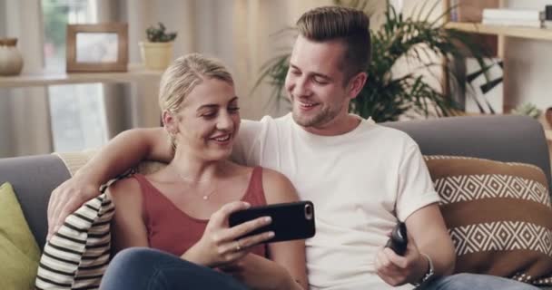 Couple, couch and phone for funny video with laughing, relax and bonding on meme, web and social network app. Man, woman and sofa in home living room with smartphone, movie or streaming subscription. - Footage, Video