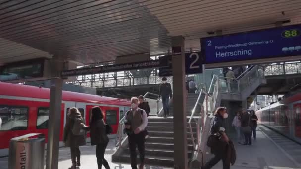 15. dubna2022. Mnichov, Německo. S-Bahn stanice Hackerbrucke v Mnichově, Bayern.Téma veřejné železniční dopravy v Německu. Příměstský rychlík Deutsche Bahn v červené barvě ve stanici.  - Záběry, video
