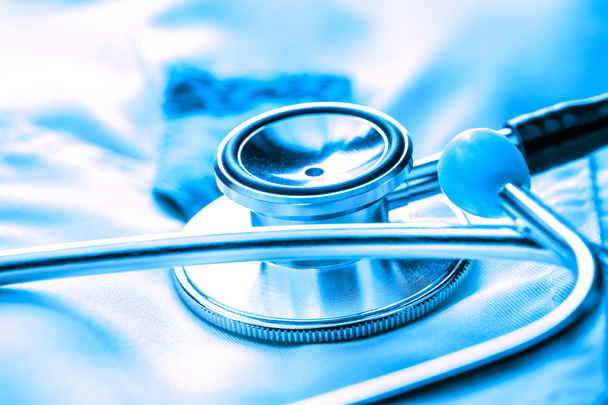 Stethoscope on white medical coat - Foto, imagen