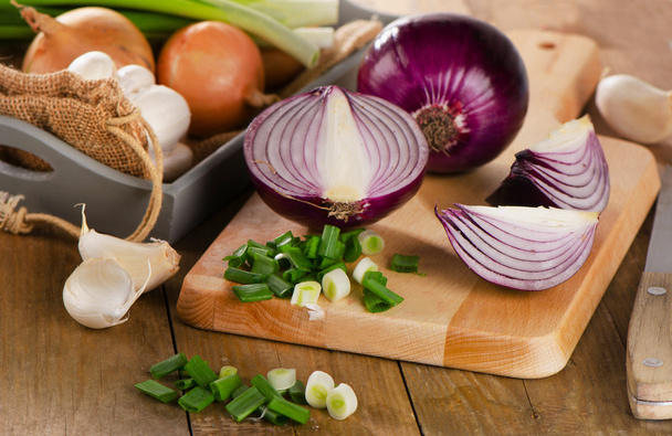 Fresh onions on cutting board - Fotó, kép