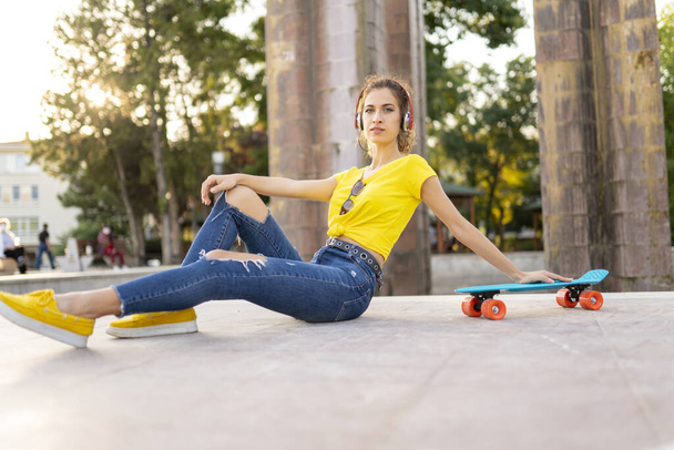Fiatal modern nő a szabadban a városban gördeszkával - Fotó, kép