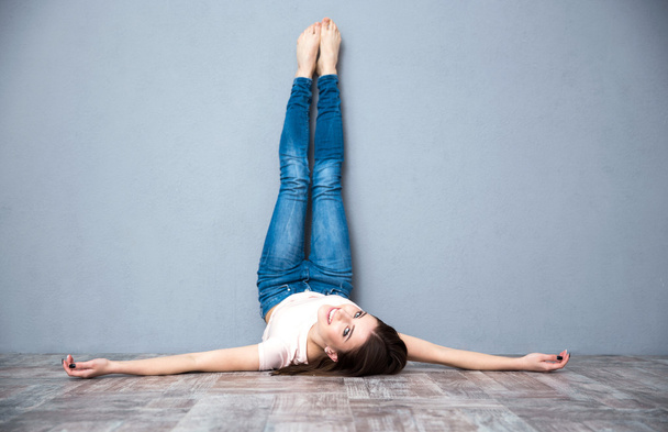 Woman lying on the floor with legs raised up - Fotoğraf, Görsel