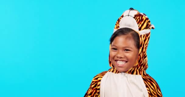 Tiger costume, laughing and face of girl in studio isolated on a blue background mockup space. Portrait, funny and happy child with comedy, humor and smile for positive mindset in animal cosplay - Footage, Video