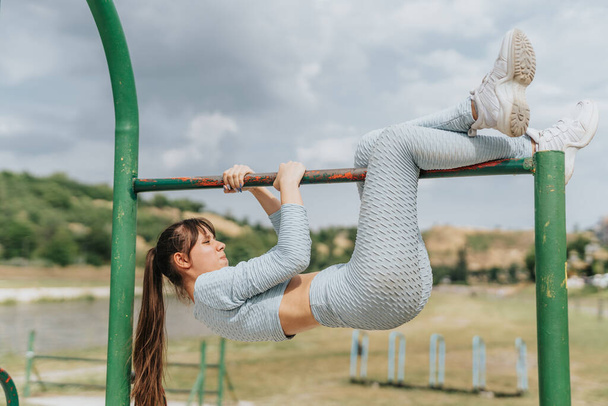Active fit girls training together in an urban park, inspiring a healthy and energetic lifestyle. They engage in cardio exercises, muscle training, and stretching. - Foto, imagen