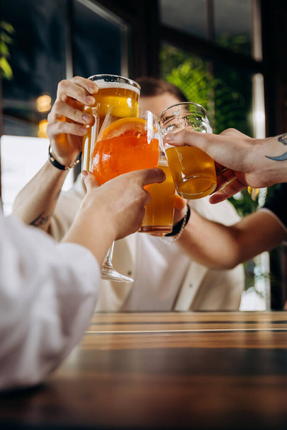 Друзья пьют пиво и пьют коктейли в ресторане паба - Фото, изображение