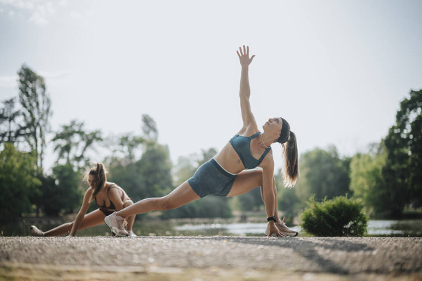 Fit meisjes inspireren met outdoor workout in Green Park - Foto, afbeelding