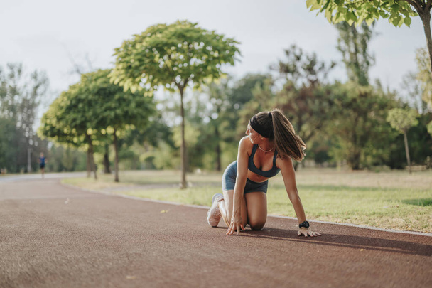 Atraktivní atletické ženy jogging v zeleném parku, ukazuje fit těla a cvičení motivaci. - Fotografie, Obrázek