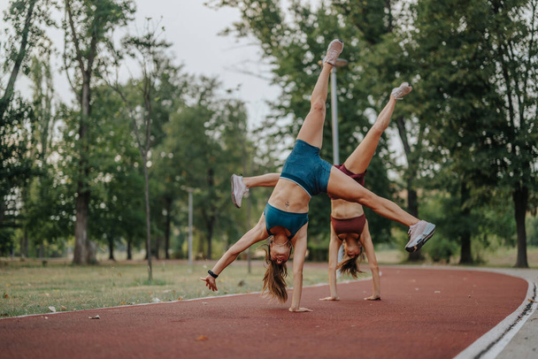 Flips and Cartwheels: Siostry lekkoatletyczne Zaakceptuj fitness w przyrodzie Plac zabaw - Zdjęcie, obraz
