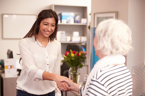 Receptionist Greeting Female Patient - Photo, Image