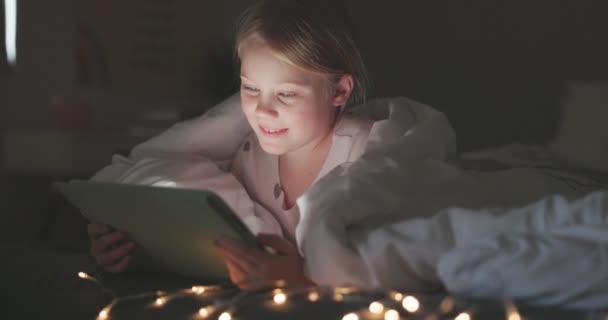 Happy girl, kid and tablet in bedroom at night for online games, reading ebook story or educational web app. Dítě, digitální technologie nebo připojení pro streamování kreslených filmů, médií nebo relaxaci s přikrývkou. - Záběry, video