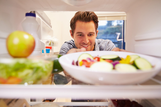 Homem olhando dentro da geladeira
 - Foto, Imagem