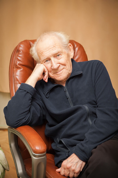 portrait of a smiling old man in a chair - Zdjęcie, obraz