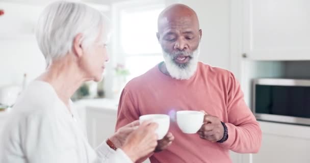 Elderly, couple or coffee with communication in kitchen for relax, peace and bonding in interracial relationship. Senior, black man or woman drinking tea with conversation or talking at home for love. - Footage, Video