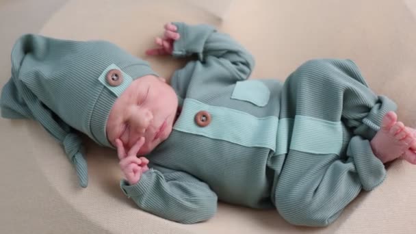 roztomilý novorozeně dítě v zeleném oblečení ležící v posteli - Záběry, video