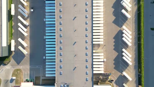 Вид с воздуха на товарный склад. Логистический центр в промышленной зоне города сверху. Вид с воздуха на погрузку грузовых автомобилей в логистическом центре - Кадры, видео