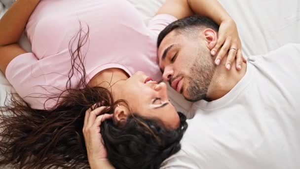 Mann und Frau liegen auf Bett und küssen sich im Schlafzimmer - Filmmaterial, Video