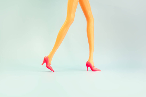 Doll legs on blue background, copy space. - Photo, Image
